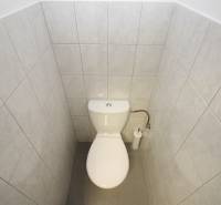 A restroom with white tiles in commercial premises.