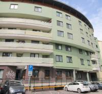 Apartment building with a curved structure, parking spaces in front of the entrance on Žatevná Street, Dúbravka.
