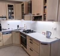 A kitchen in a 4-room apartment with wooden cabinets and modern appliances.
