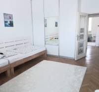 A bright bedroom with a large wardrobe and a wooden bed in a 4-room apartment.