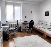 A room with two desks and a bed in a 4-room apartment.