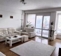 A bright living room with white sofas in a 4-room apartment, glass doors to the terrace.