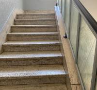 A staircase with a glass railing leads to a window in a 4-room apartment.