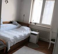 Bedroom with a bed, lamp, and window in a 4-room apartment.
