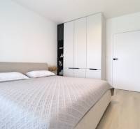 Bedroom in a 3-room apartment with a bed and a built-in wardrobe. Minimalist design.
