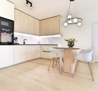 A kitchen with a dining table and chairs in a 3-room apartment.