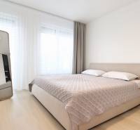 Bright bedroom in a three-room apartment with a large mirror and a bed.