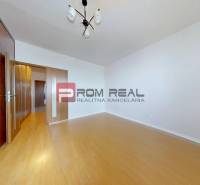 A room with a wooden floor, built-in wardrobe, and lighting in a 3-room apartment.