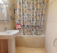 Bathroom with a sink and a bathtub with a patterned shower curtain in a 3-room apartment.