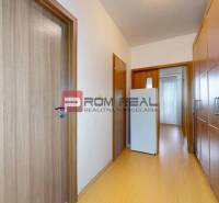 A hallway in a 3-room apartment with built-in closets and light wooden paneling.