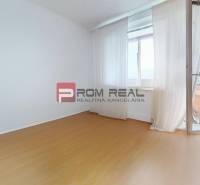 An empty room in a 3-room apartment with laminate flooring and a balcony.