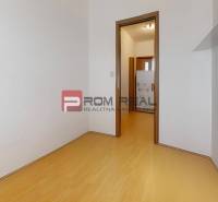 A room with a wooden floor and white walls in a 3-room apartment.