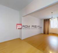 Interior of a 3-room apartment with laminate flooring and curtains on the window.