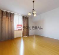 An empty room with wooden flooring and curtains, 3-room apartment.