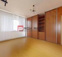 A room in a 3-room apartment with a wooden wardrobe and a ceiling light.