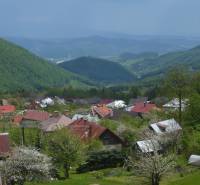 A view of the cottages in Kordíky near Banská Bystrica with picturesque hills in the background.
