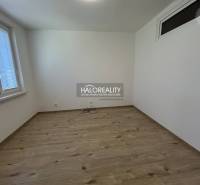 Empty room with wooden floor and two windows in a 3-room apartment.