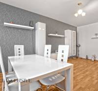 Dining room in a 2-room apartment with wooden flooring and white furniture.