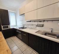 A kitchen in a 3-room apartment with a wooden countertop and built-in appliances.