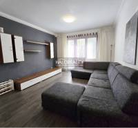 Living room in a 3-room apartment with a sofa and a dark wall.