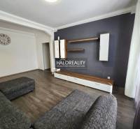 Living room in a 3-room apartment with a dark sofa and furniture.
