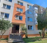 Apartment building in Tlmače, suitable for a two-room apartment, surrounded by greenery and trees.