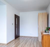 Interior of a family house with wooden flooring, furniture, and a houseplant on the table.