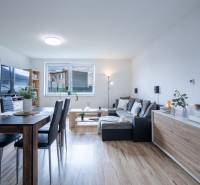Dining room in a family house with wooden flooring, large windows, and modern furniture.