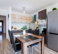A kitchen in a family house with a wooden floor and kitchen equipment including appliances.