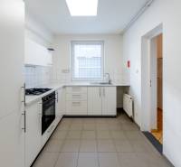A kitchen with white cabinets, appliances, and a window in a family house.