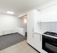 A kitchen with white cabinets, an electric oven, and a stove in a family house.