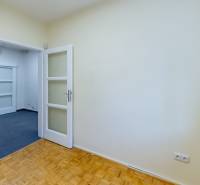 A room in a family house with a wooden floor, white doors, and a carpet.
