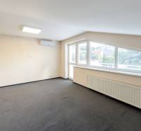 A bright room in a family house with a carpet and air conditioning, large windows with blinds.