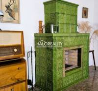 Green tiled stove, vintage radio, and decorations in the interior of a family house.
