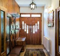 A hallway in a family house with wooden paneling and a bench for sitting.