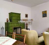 Living room in a family house with a tiled stove, retro furniture, and paintings on the walls.