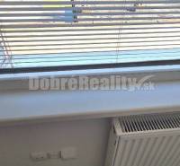 Blinds on the window in an office with a radiator and carpet.