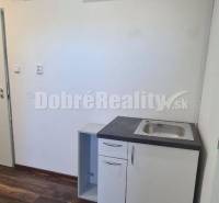 Air conditioning and a sink in an office with wooden flooring.
