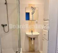 Bathroom in offices with a sink, shower, and storage space.