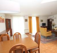Living room in a family house with a dining table, sofa, and television.