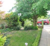 The garden of a family house in Bratislava on Nové Záhrady VII with a lawn and trees.