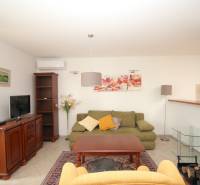 Living room of a family house with a sofa, armchair, cabinet, and television.