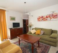 Living room in a family house with a sofa, armchair, table, and television.