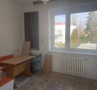 Interior of a family house with a window, table, and orange bench.