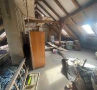 Attic in a family house with beams, skylights, and stored items.