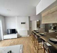 A bright living space with a television, kitchen, and dining counter in a 3-room apartment.