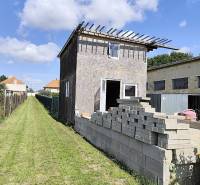 A building in Jelšovce with an unfinished exterior, intended for land - housing.