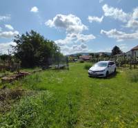 Green plot with a car in Jelšovce, suitable for living.