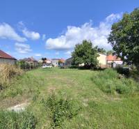 Plots - housing in Jelšovce with a view of the surrounding houses and blue sky.