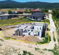 A family house construction in Trenčianske Jastrabie, surrounded by rural landscape and neighboring houses.